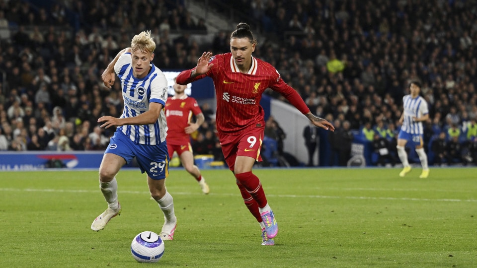 Darwin Nunez of Liverpool runs with the ball under pressure from Jan Paul van Hecke of Brighton & Hove Albion
