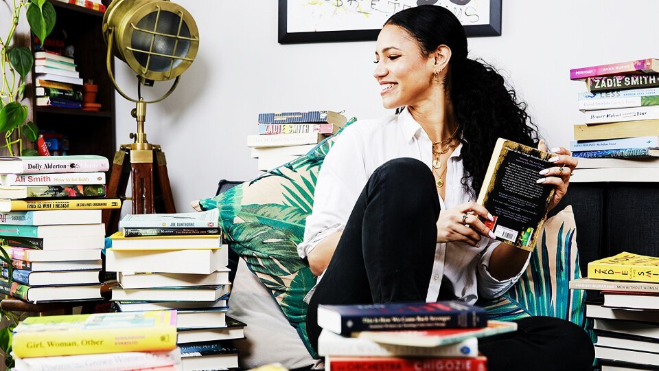 A woman in a room of books.