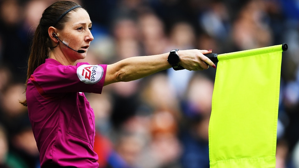 A Premier League assistant referee flagging for offside.