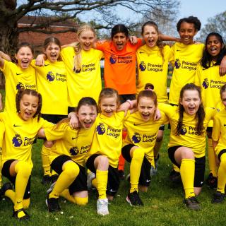 A group of school kids wearing Premier League t-shirts