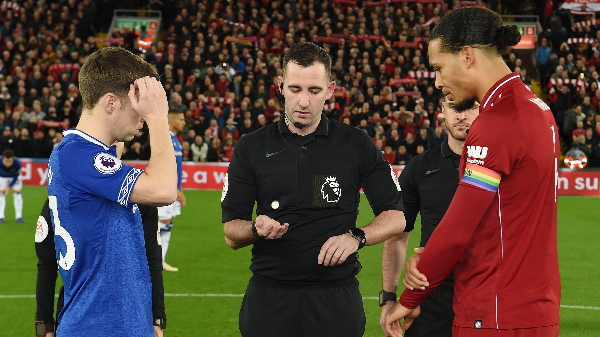 A referee tosses a coin to decide which team kicks off.