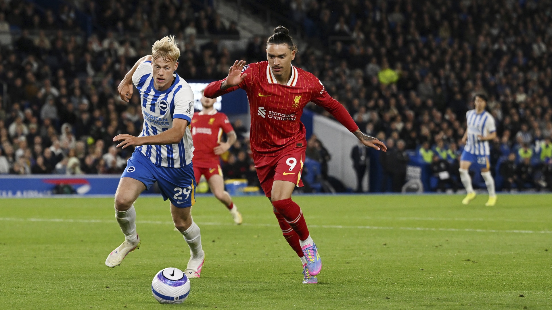 Darwin Nunez of Liverpool runs with the ball under pressure from Jan Paul van Hecke of Brighton & Hove Albion