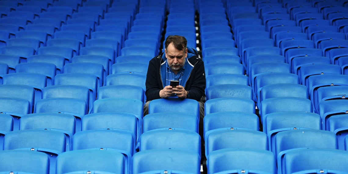 A lone supporter checks his phone