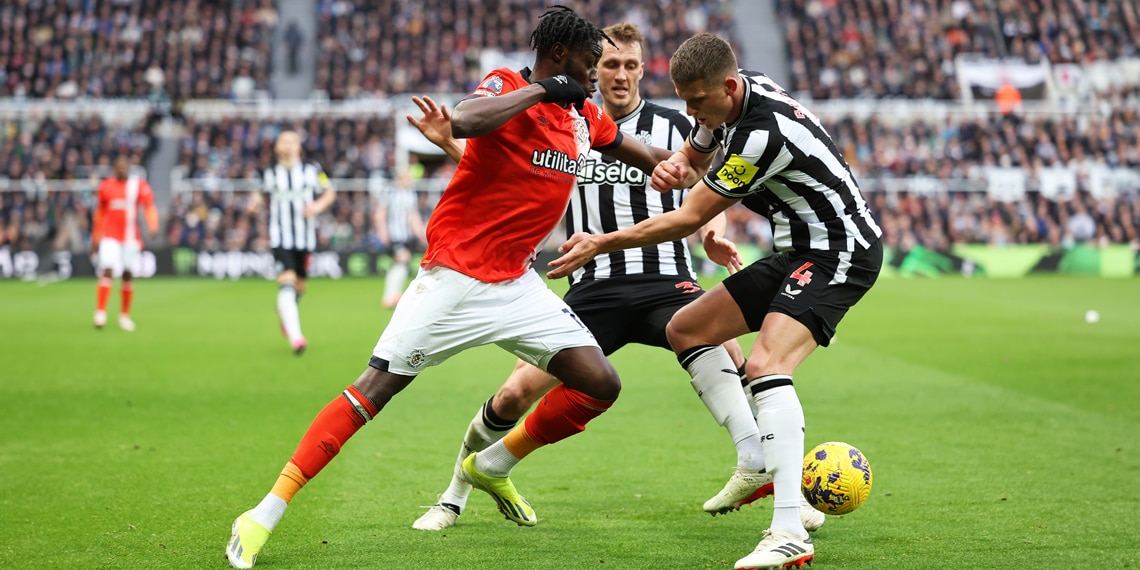 Elijah Adebayo takes on Sven Botman and Dan Burn of Newcastle United during the match between Newcastle United and Luton Town