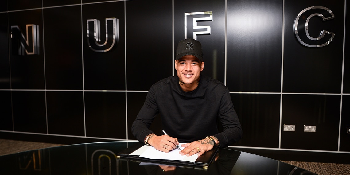 Kenedy signs his contract at Newcastle United.