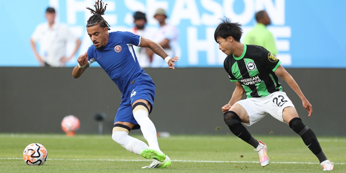 Malo Gusto of Chelsea and Kaoru Mitoma of Brighton & Hove Albion fight for the ball during the first half