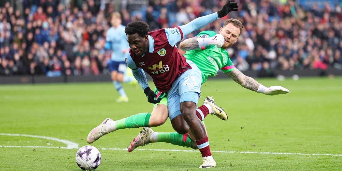 Mark Flekken of Brentford tackles David Datro Fofana of Burnley during the match between Burnley and Brentford