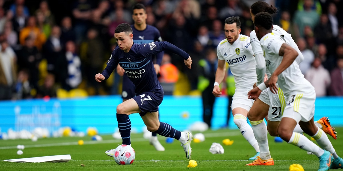 Phil Foden of Manchester City runs ahead of Pascal Struijk and Junior Firpo of Leeds United