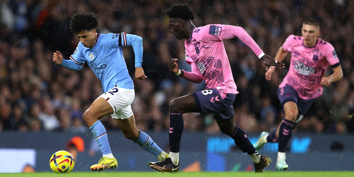 Rico Lewis of Manchester City battles for possession with Amadou Onana of Everton