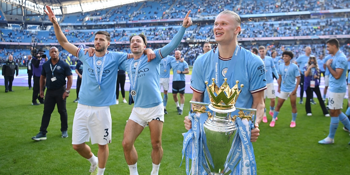 Ruben Dias, Jack Grealish and Erling Haaland of Manchester City celebrate with the Premier League trophy