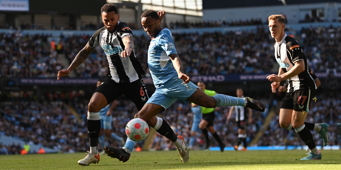 Manchester City player Raheem Sterling shoots at goal despite the attentions of Jamaal Lacelles of Newcastle