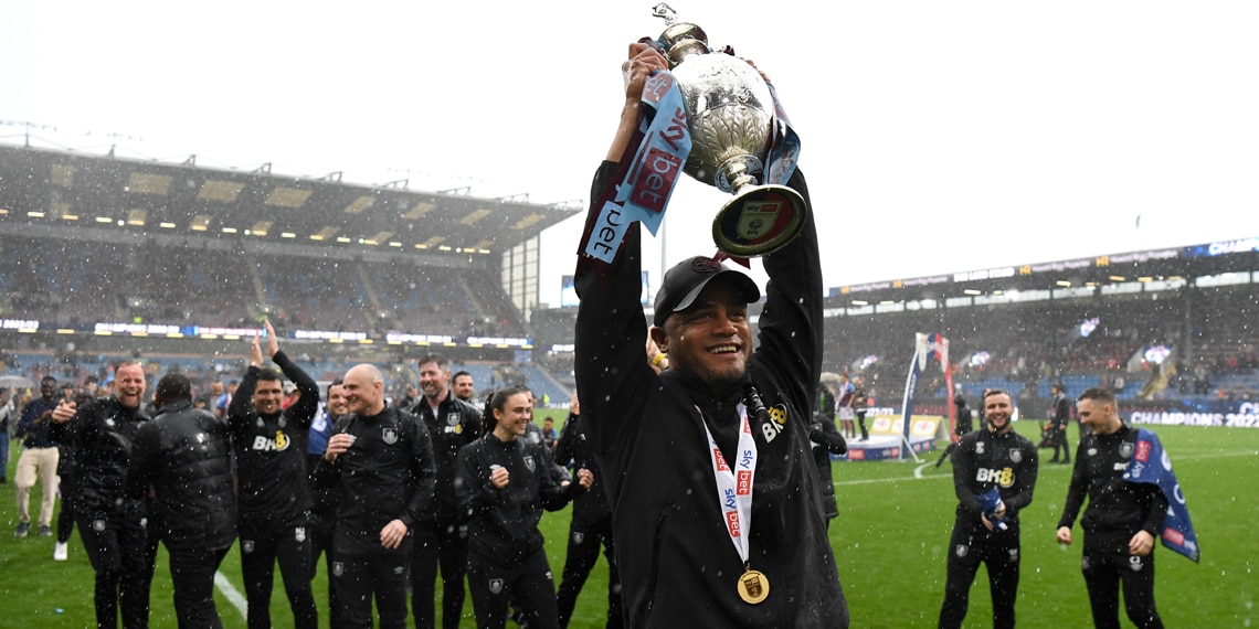 Vincent Kompany holds the Premier League trophy on board a parade bus during the Manchester City Celebration Parade