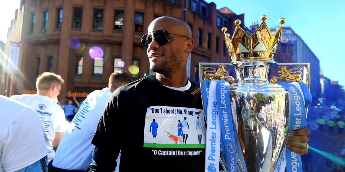 Vincent Kompany holds the Premier League trophy on board a parade bus during the Manchester City Celebration Parade