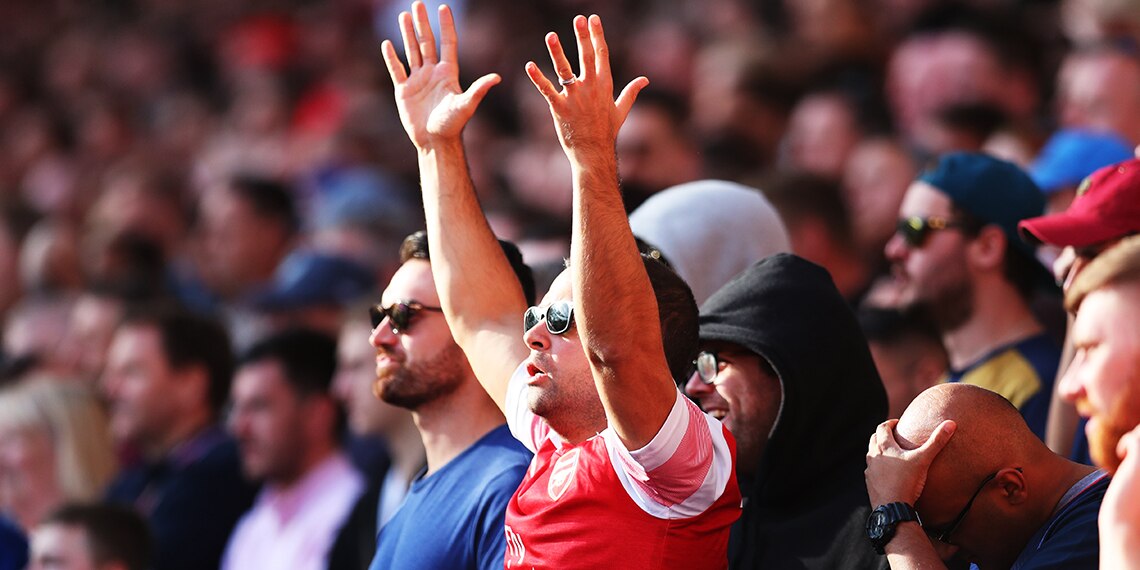 The fan in the Arsenal shirt looks angry but it's the bloke behind him who should be really angry. He can't see a thing when the Arsenal fan stands up!