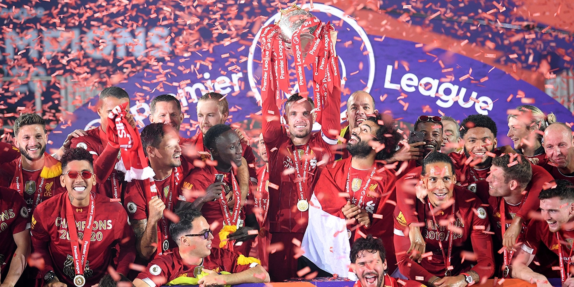 Liverpool players and staff lift the Premier League trophy.