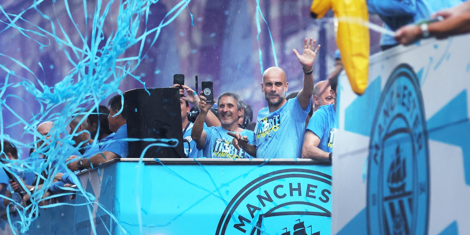 manchestercitymanagerpepgardiolawavesfromthebackofthebusasplayersofmanchestercitycelebrate-Enhanced-SR