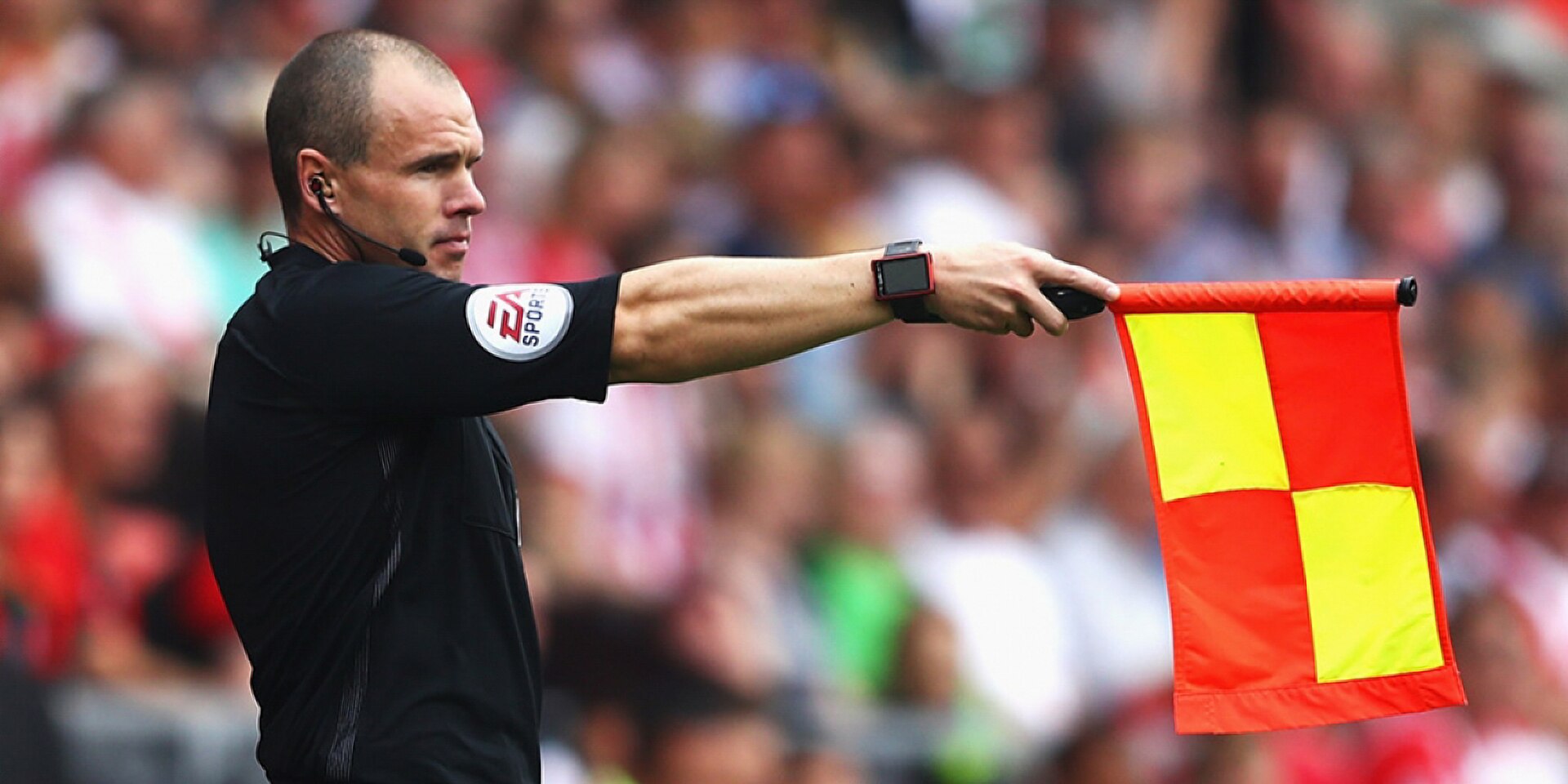 An assistant referee with his flag up.