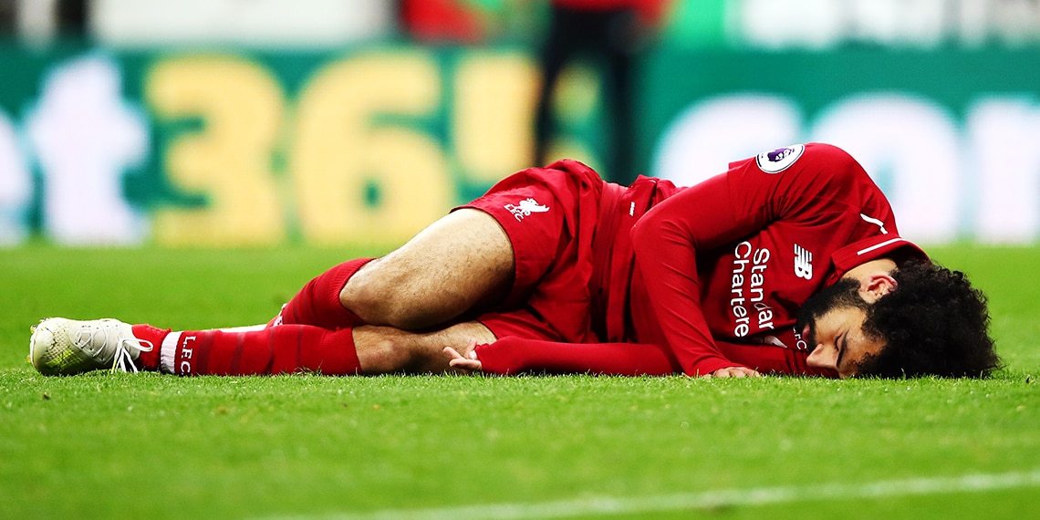 Mohamed Salah injured during a match for Liverpool.